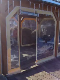 Transparente PVC-Plane mit integrierter Tür an einem Holzpavillon