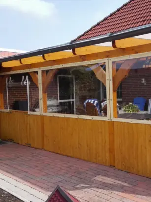 Transparente PVC-Planen mit hellem Saum an einer überdachten Terrasse