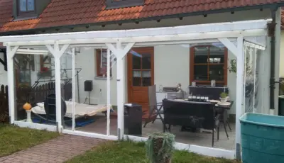 Transparente PVC-Planen als Windschutz an einer überdachten Terrasse